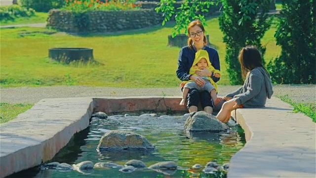年轻的母亲和两个女儿在公园里玩视频素材