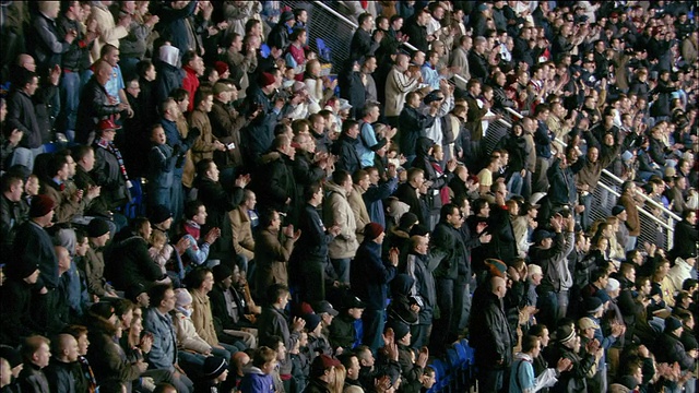 高角度长镜头观众站在体育场欢呼/挥杆击球到体育场另一边的人群欢呼视频素材