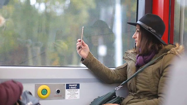 一名年轻女子在公交车上用手机自拍视频素材