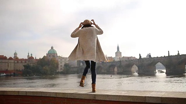 年轻女子在布拉格，查尔斯桥旁玩视频下载