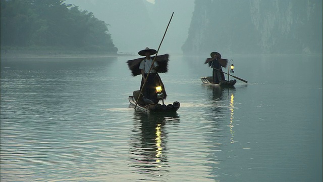 黄昏时分，中国广西漓江上的两位传统鸬鹚渔民视频下载