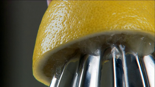 近距离的柠檬被挤在柑橘汁机视频素材