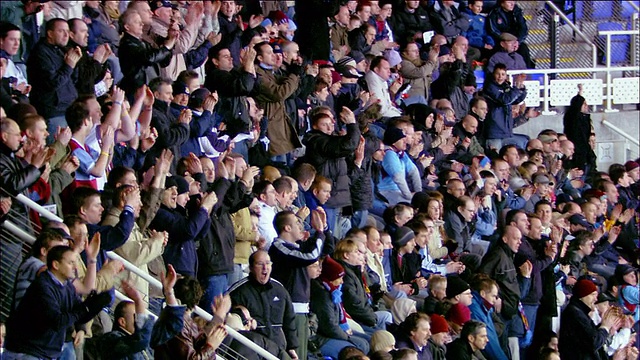 高角广角镜头倾斜下倾斜上缩小观众在足球比赛中欢呼和鼓掌在马德斯基体育场/雷丁，英格兰视频素材