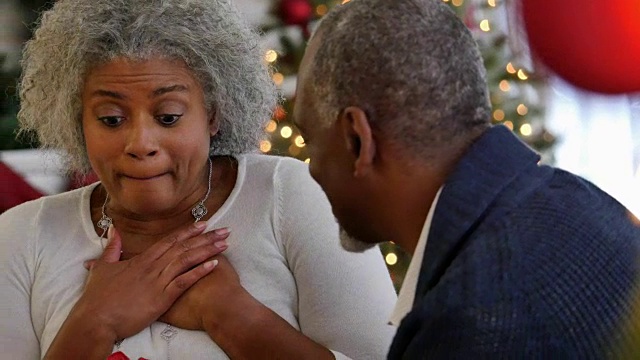 美丽的高级非洲裔美国妇女兴奋地收到来自丈夫的圣诞礼物视频素材