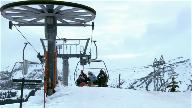 低角度中镜头女子和两名男子从滑雪缆车滑雪到山顶，法国莫辛视频素材