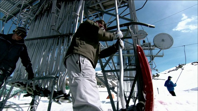 低角度中镜头平底滑雪板抓住按钮滑雪升降机和骑上山视频素材