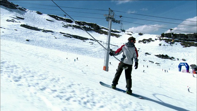 中等镜头跟踪拍摄滑雪板骑按钮滑雪缆车山坡/莫尔津，法国视频素材