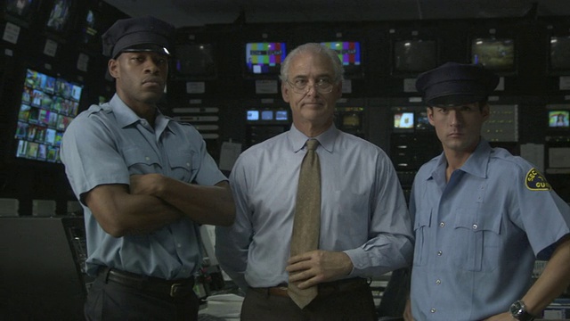 美国加州卡尔弗城，两名保安和一名商人站在电视演播室控制室里视频素材