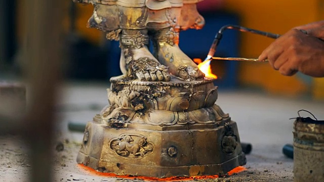 焊工焊接钢雕和修复佛像的细节，同时产生火花和烟雾。视频下载