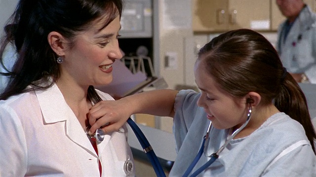 德克萨斯州埃尔帕索，医生给小女孩/女孩用听诊器听医生的心跳视频素材
