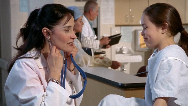中景放大，医生用听诊器听小女孩的心跳/德州埃尔帕索视频素材
