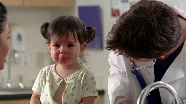 德州埃尔帕索，一名中等剂量的医生在检查期间为哭闹的孩子擦眼泪视频素材