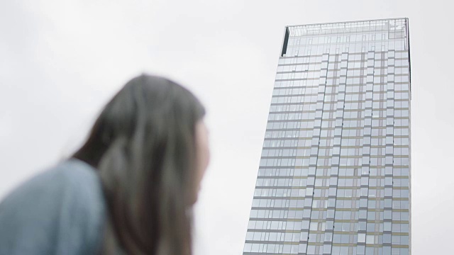 年轻女子望着摩天大楼视频素材