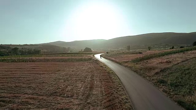 无人机视角下的男人在路上骑摩托车视频素材
