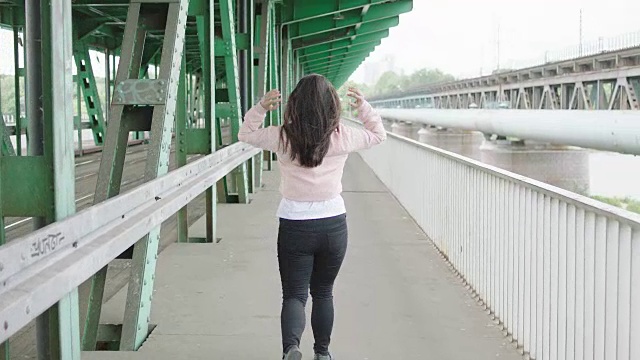 年轻女子在桥下行走视频素材