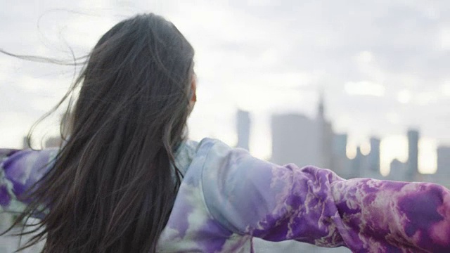 亚洲妇女在屋顶上打开双臂视频下载