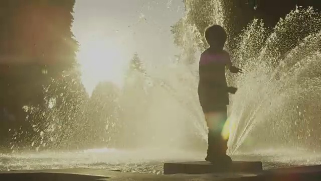 男孩在公园喷泉附近跳舞视频下载