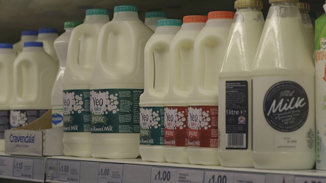 英国一家大型超市冷藏货架上各种品牌的牛奶的序列。视频下载