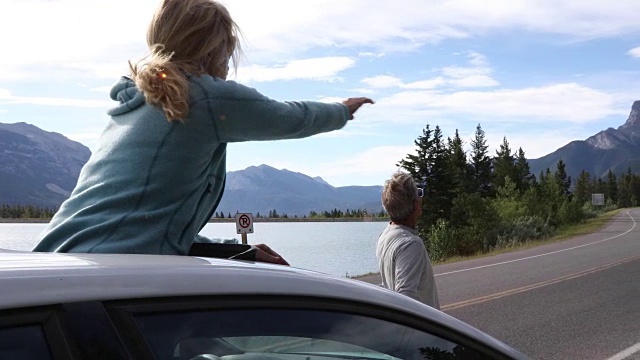 夫妇把车停在湖边的路上，走进了山景视频素材