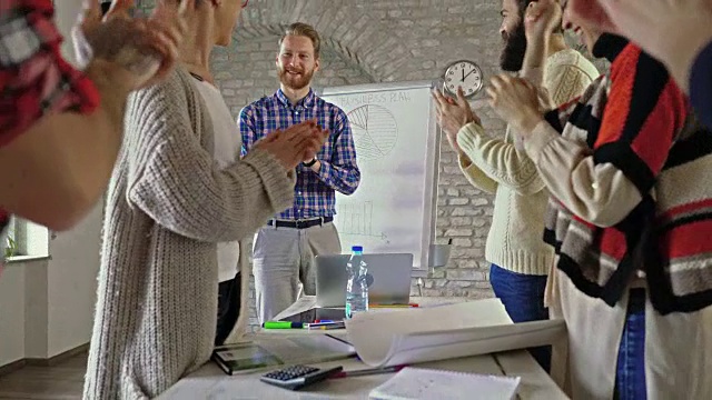 快乐的创业团队在办公室为同事的出色的业务演示鼓掌。视频素材
