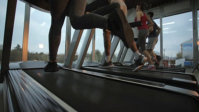 下图是运动员在健身房里的跑步机上慢跑。慢动作。视频素材