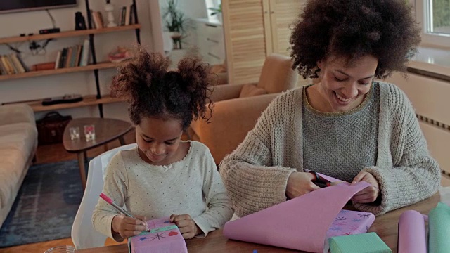 创造性的非洲裔美国母亲和女儿有乐趣，而装饰礼品盒。视频素材