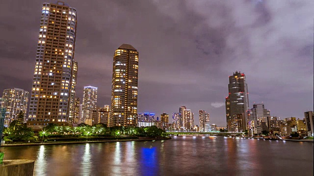4K时光流逝，日本东京筑岛中央区夜晚高楼大厦和游艇照亮的东京城市天际线。视频下载
