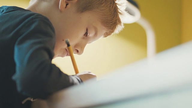 男孩(10-11)在书桌上做作业的特写视频素材