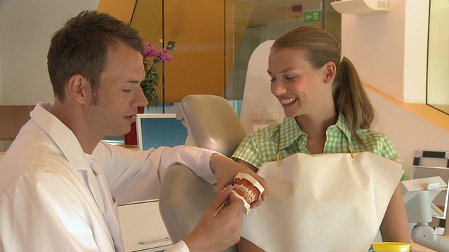 德国柏林，一名牙医向一名女病人解释牙齿模具视频下载