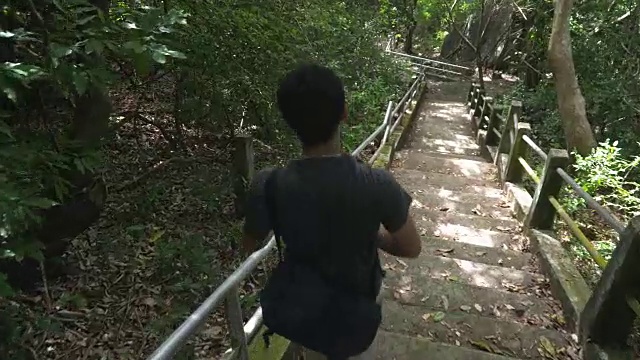 在热带森林里，一位泰国年轻人正从梯子上走下来视频素材