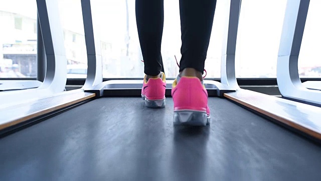 亚洲女性健身和在健身房的机器上跑步视频素材