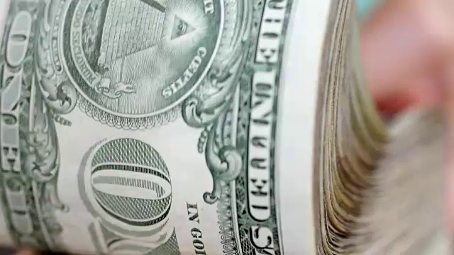 女人在一大堆美国货币中扇动。视频下载