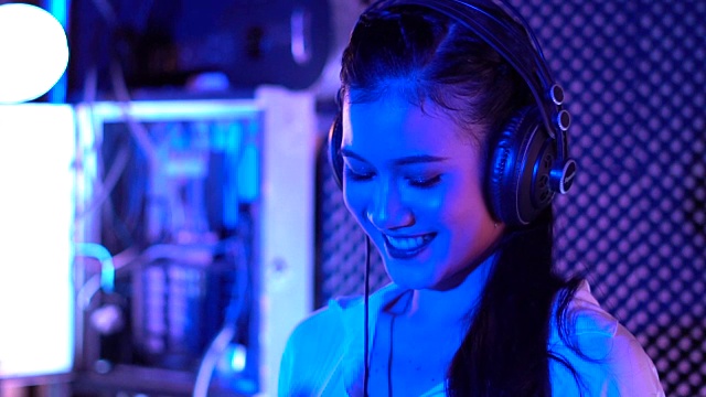 亚洲女DJ在DJ的甲板上调整各种轨道控制视频下载