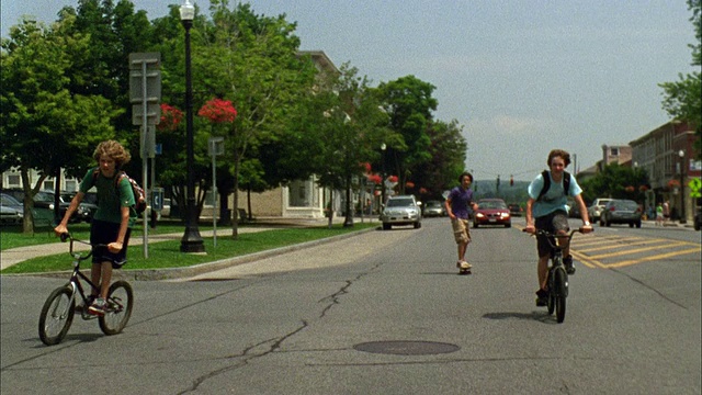 WS TS PAN ZI男孩骑自行车和滑板在路上/卡泽诺维亚，纽约，美国视频素材
