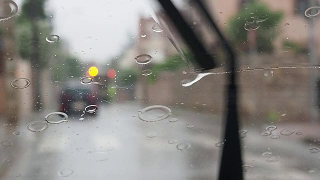 水滴落在汽车玻璃上的景象。挡风玻璃的刮水器工作了。马德里,西班牙视频下载