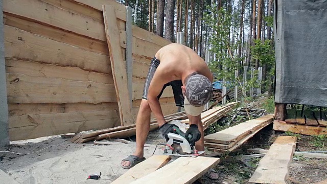 建筑工用圆锯切割木板。视频下载