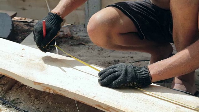 木匠在木板上测量尺寸。视频下载