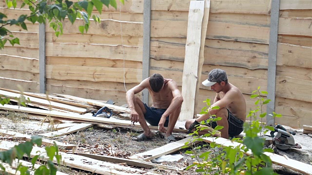 工人们在建造木栅栏后休息。视频下载