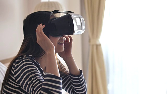 在家里戴着虚拟现实眼镜的女人，慢镜头视频下载