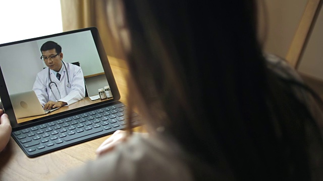 女病人在家里用平板电脑与医生视频交谈视频下载