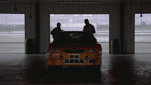 美国宾夕法尼亚州，Long Pond，两名赛车手从停在车库的汽车上取下盖子视频下载
