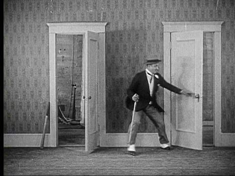 1924年，女人(路易斯·卡弗)用木板追赶男人(查尔斯·默里)，他躲起来，她用木板打门，然后男人用木板打女人/美国视频素材