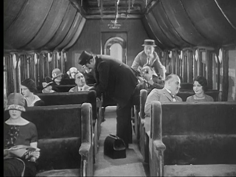 1924 B/W蒙太奇MS WS Man (Harry Langdon)试图从列车长(Tiny Ward)身边走过/ MS Man跳过座位，踩到另一个人的帽子/ USA视频素材