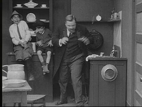 1913年B/W蒙tage MS Man(胖子Arbuckle)把男孩扔出家门，朝他们扔盘子和椅子，然后摔倒/美国视频素材