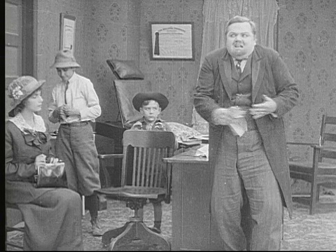 1913年B/W蒙太奇MS Man(胖子Arbuckle)抓男孩并把他们踢到其他房间/美国视频素材