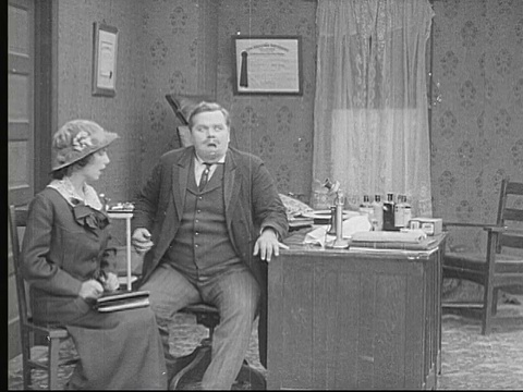 1913年美国，男孩们吃得乱七八糟，摔盘子，而男人(胖子阿巴克尔)在隔壁和女人说话视频素材