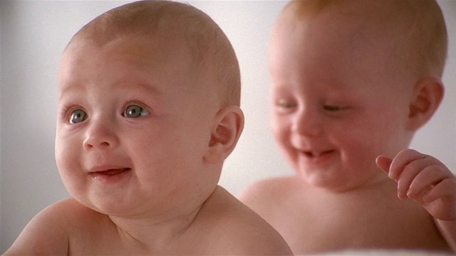 近距离拍摄的双胞胎宝宝/一个坐在另一个前面视频素材