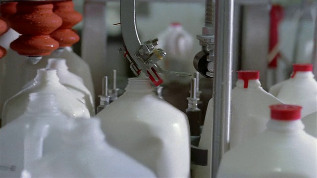 在乳品厂关闭盛满牛奶的塑料罐视频下载