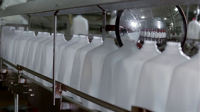 关闭盘式塑料罐在传送带上被反射在镜子在乳品工厂视频下载