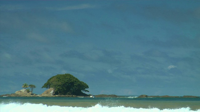 蓝色的天空下，海浪流过Playa Uvita小岛/ Puntarenas省，哥斯达黎加视频下载